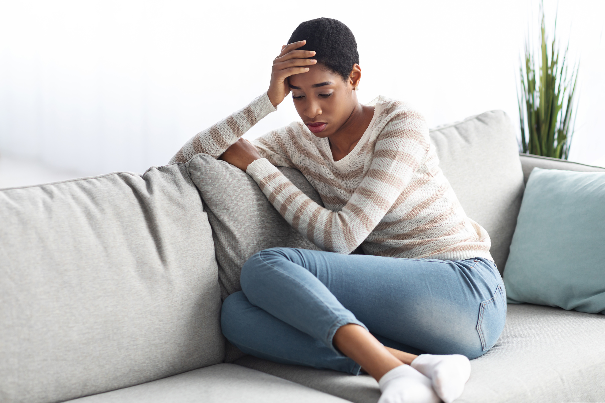 Seasonal Depression. Portrait Of Sad Black Female Sitting On Sofa At Home